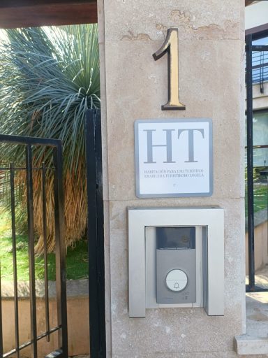 Número 1 en la fachada con un timbre y letrero "HT" adjunto.
